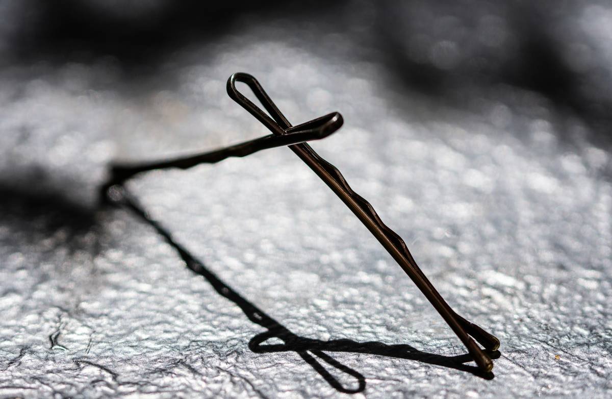 Side-by-side comparison of plastic vs. satin-coated metal decorative pins under magnification showing smooth vs. jagged edges